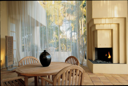 Architect Ken Ronchetti designed an ultra-modern outdoor living room for this southern California home. A transparent fabric wall can be drawn across the opening of the space to protect it from flying insects.
